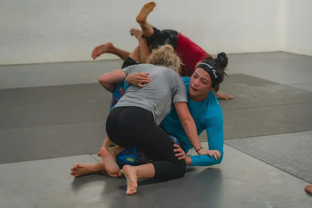 Women practicing self defense techniques on a mat.