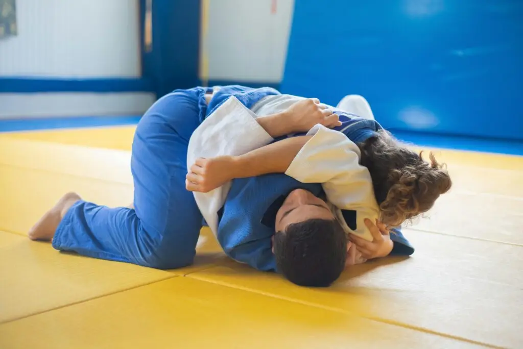 Two people participating in jiu jitsu.