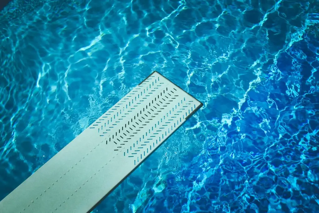 Diving board on top of a pool.