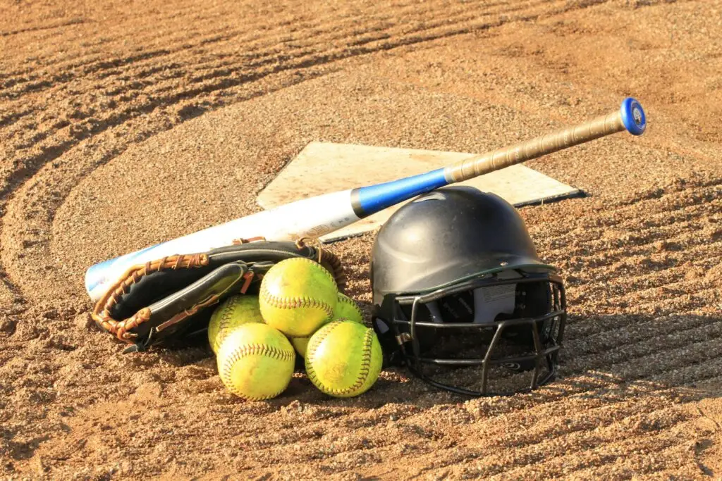 Softball gear on dirt field.