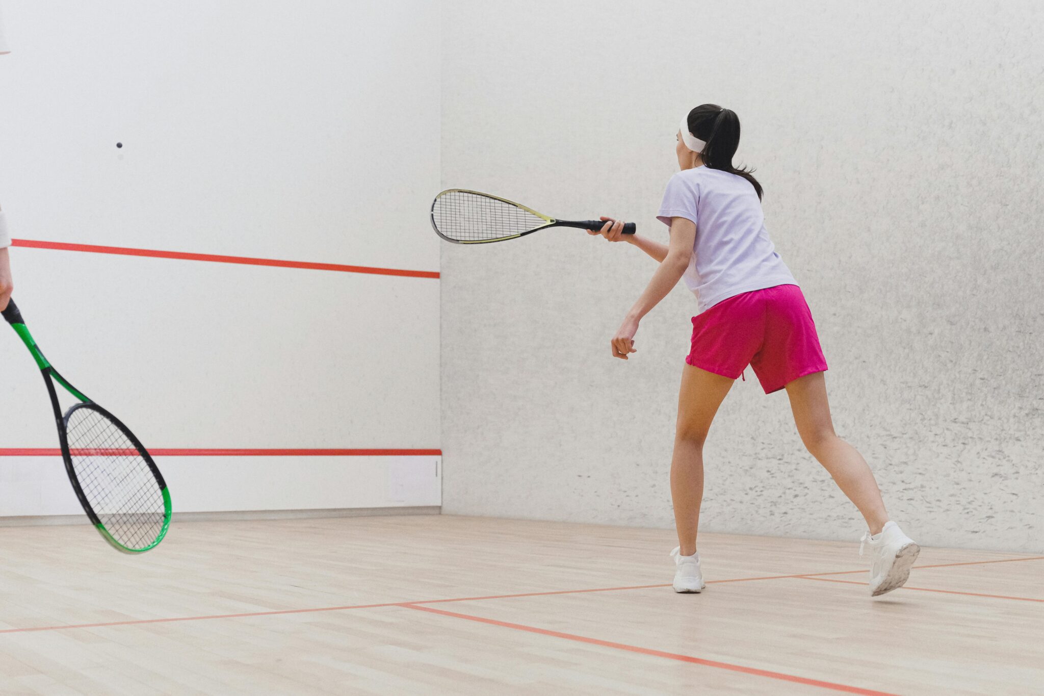 Racquetball game being played indoors.