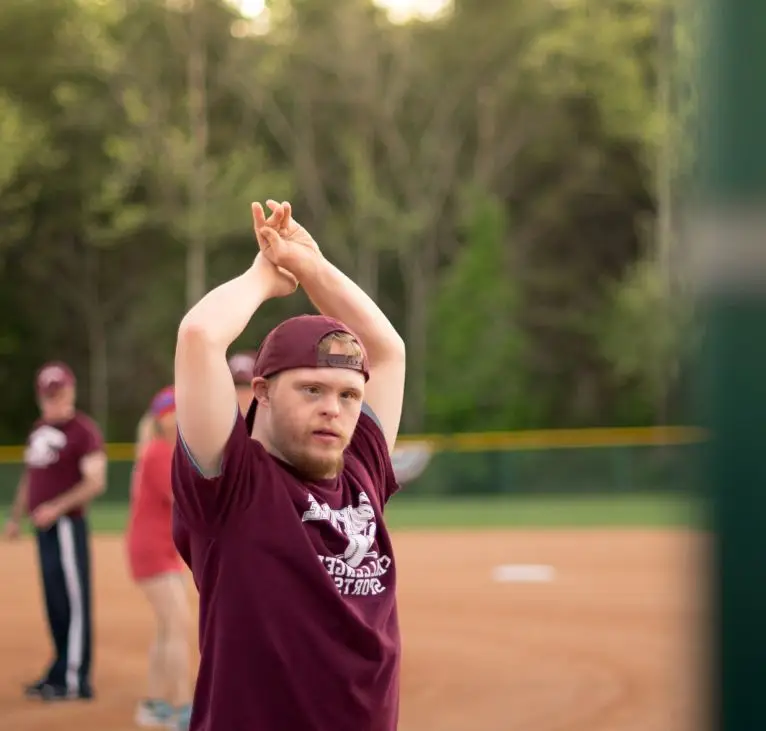 A picture of a young man stretching to play a baseball game.